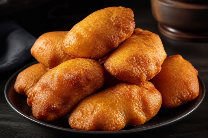 Festival Dumplings: Flavored flour dumpling fried crystal golden brown, a classic Jamaican side bite.